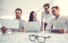 Business people are using gadgets and examining documents while working in office