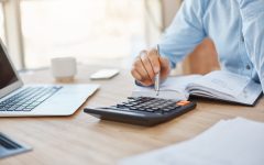 close-up-detail-professional-serious-accountant-sitting-light-office-checking-company-finance-profits-calculator
