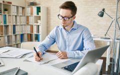 Businessman making notes or writing plans for working day